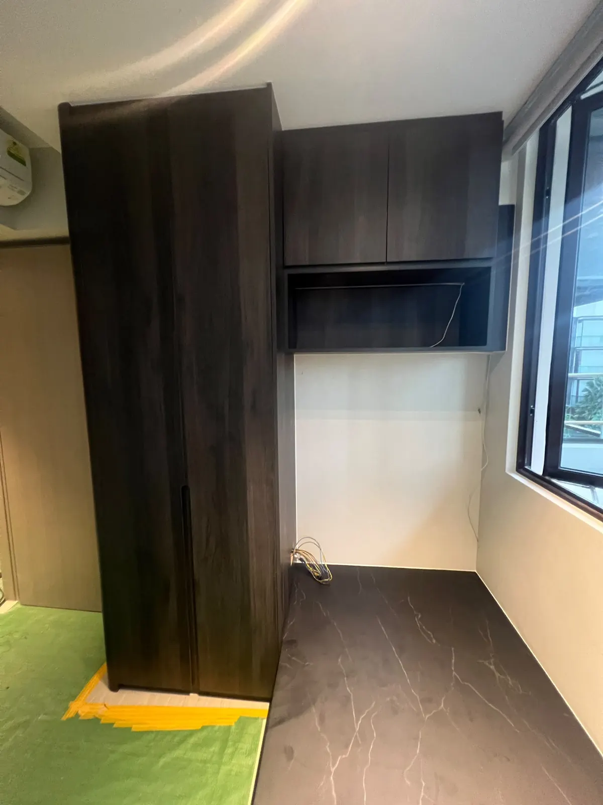 Dairy Farm Residences bedroom with a full-height wardrobe, top-hung cabinet and raised bed platform